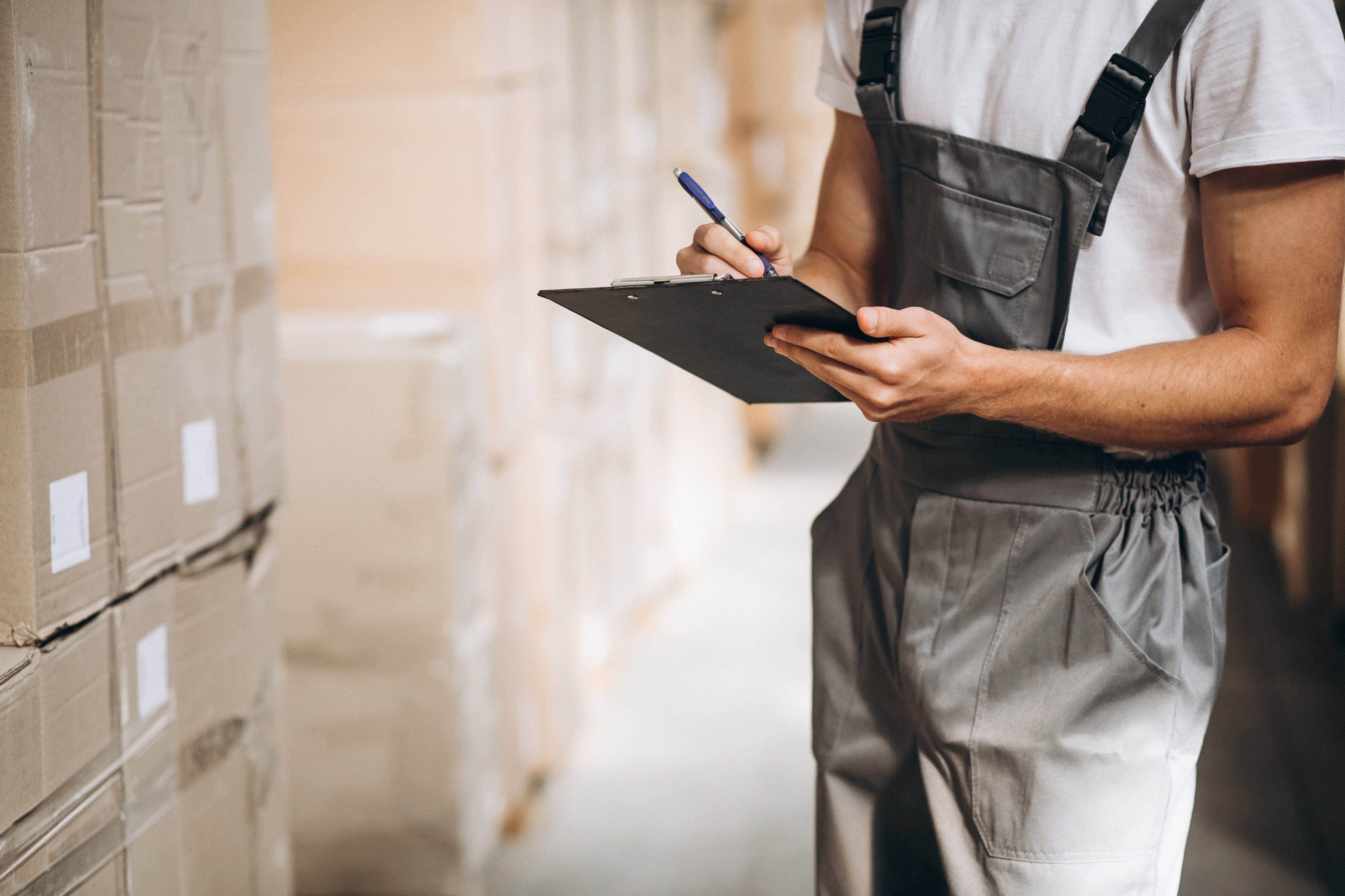 young-man-working-warehouse-with-boxes young-man-working-warehouse-with-boxes